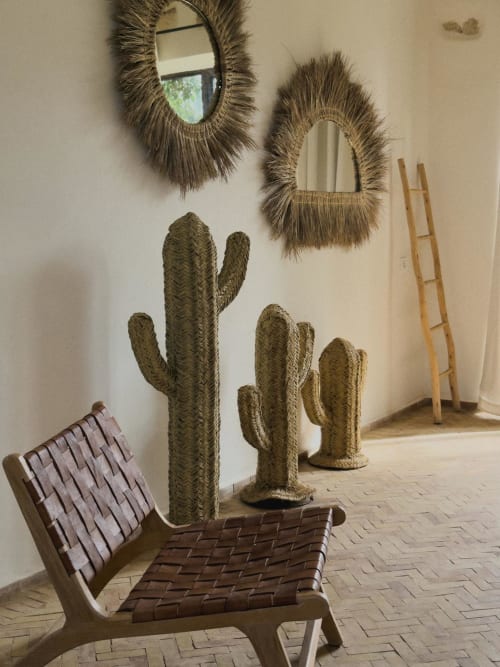 Habitación de inspiración bohemia con objetos de mimbre, espejo trenzado, asiento de cuero y madera, escalera de madera de eucalipto en el Riad Eucalyptus en Essaouira