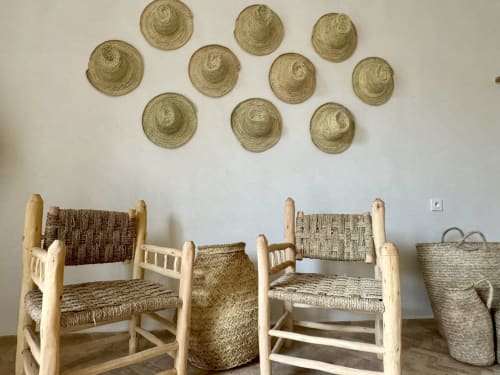 Decoración de una habitación bohemia con sombrero de mimbre, cesta, sillón estilo beldi de madera de eucalipto y mimbre, suelo de bejmat en el Riad Eucalyptus en Essaouira