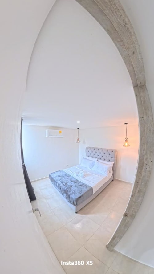 Moderna habitación con cama queen y lámparas colgantes en el hotel Olamar Living de Coveñas, Colombia