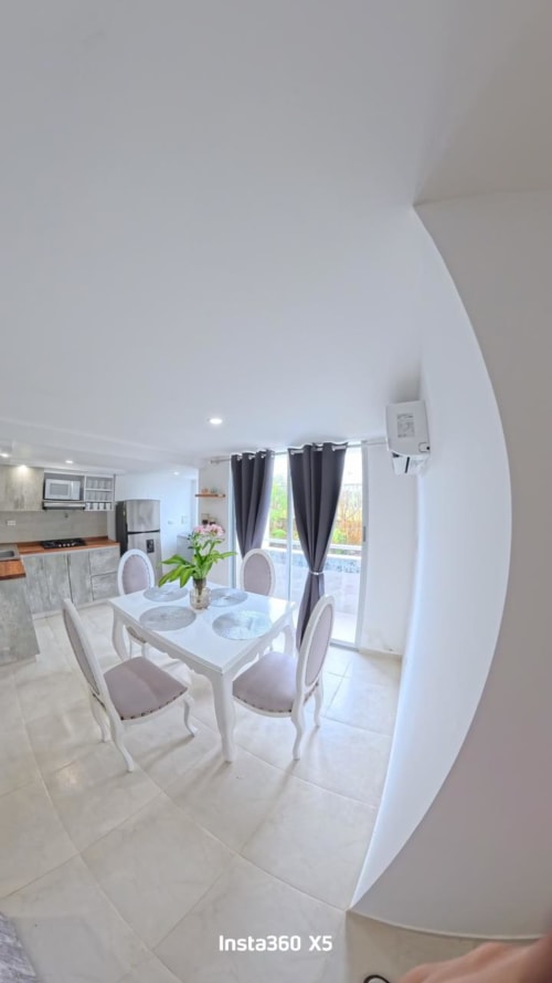 Comedor moderno en el apartamento The Coveñas Retreat del hotel Olamar Living, Santiago de Tolú con mesa blanca, sillas y
