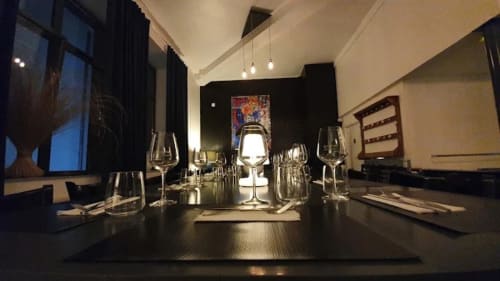 Salle à manger élégante chez Home Horizon SBL Limoges avec verres à vin, luminaires suspendus et table moderne