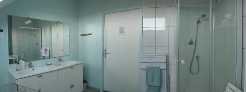 Shared bathroom at Au Coeur des Champs B&B in Regniowez with white vanity, mirror, toilet, shower enclosure and towel rack