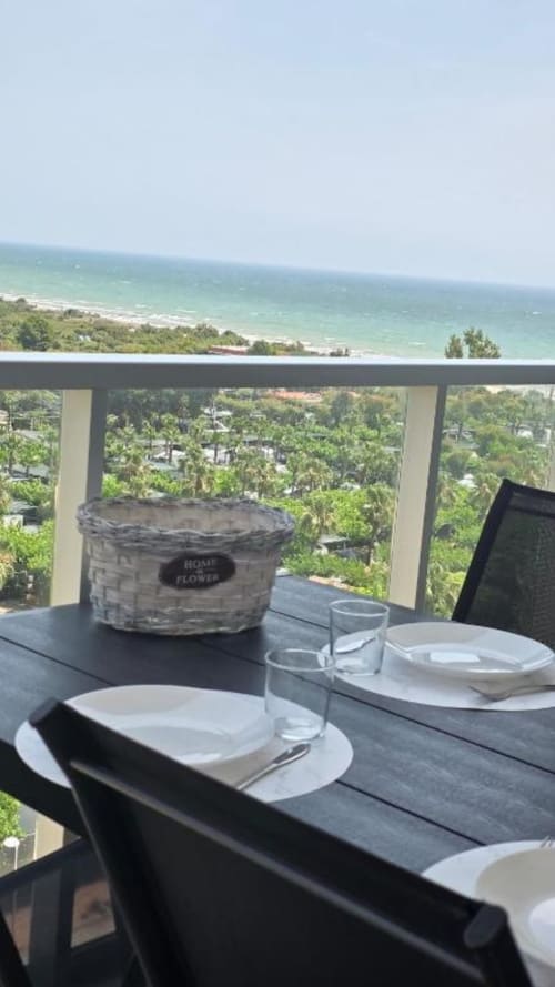 Comedor en terraza frente al mar en MiramaRent con vistas al océano, mesa preparada y paisaje costero
