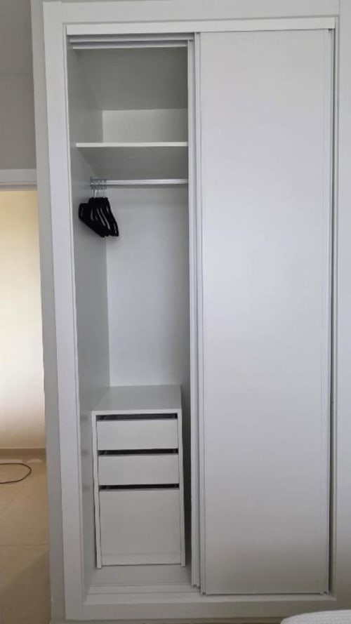 Armario empotrado blanco con estanterías, barra de colgar y cajones de almacenaje en el Apartamento Daniel de MiramaRent, Benicàssim