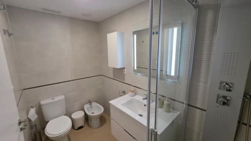 Baño moderno del Apartment Daniel en MiramaRent, Benicàssim con ducha, inodoro, lavabo y espejo