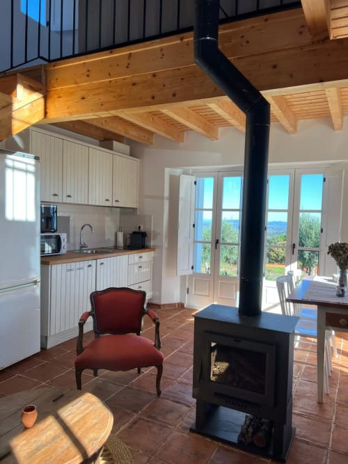 Villa moderna em Marvão com teto de vigas de madeira, fogão preto, cozinha branca e vistas panorâmicas das montanhas