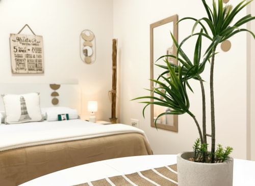 Dormitorio moderno en Holibai Baiona con ropa de cama blanca, planta en maceta y decoración minimalista