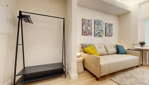 Comfortable sofa bed with clothes rack, featuring original artworks by Ralf Sannikov. Central Tartu studio near Town Hall Square, RIMI & MyFitness gym next door. WiFi & AC included