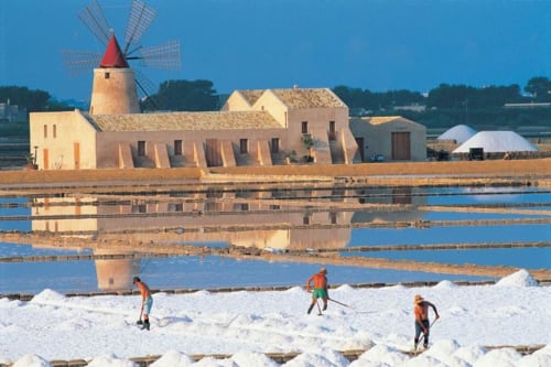 Suggestivo mulino storico presso Altavilla Boutique Holidays House a Marsala, Sicilia con vasche di sale e lavoratori in primo piano