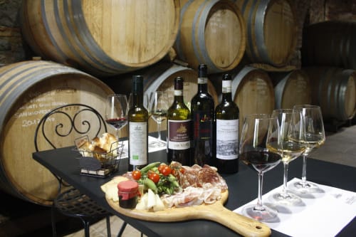Degustazione di vini presso Altavilla Boutique a Marsala con botti, bottiglie, tagliere di affettati e bicchieri