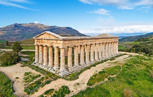 Rovine di un antico tempio greco vicino a Marsala, Italia con colline ondulate e paesaggio verde