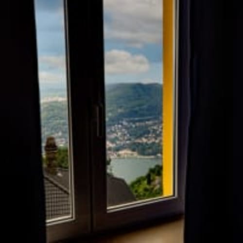 Panorama del lago di montagna dalla finestra della camera 10 dell'Hotel Vista Lago a Brunate, Italia