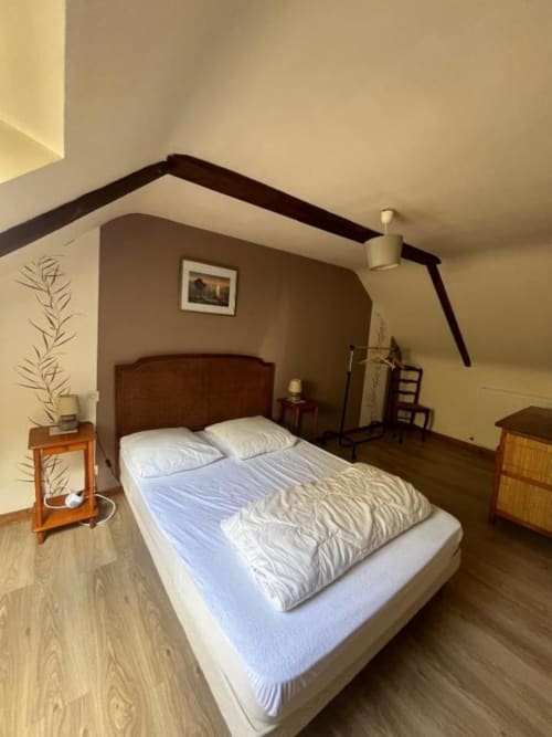 Chambre douillette au manoir de Fornebello à Châtelaudren avec lit queen-size, table de nuit en bois et plafond mansardé