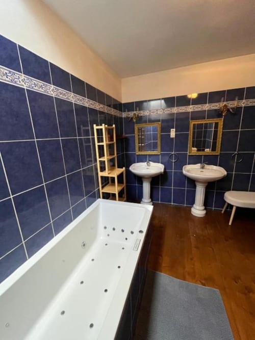 Salle de bain luxueuse Suite Seigneuriale au Manoir de Fornebello avec carrelage bleu marine, baignoire spa et vasques doubles