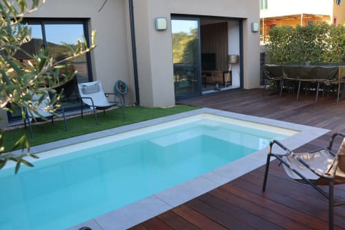 Heated pool with sun loungers and a modern villa overlooking the Corsican gardens in Favone, managed by the Corsu di Core concierge service.