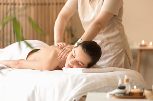 Woman receiving relaxing back massage at Sweet Holiday spa in Porto-Vecchio, serene wellness treatment