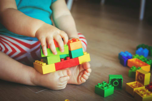 Toddler playing with colorful LEGO blocks at Sweet Holiday hotel in Porto-Vecchio