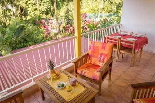 La terrasse colorée aux couleurs des Antilles du gîte BleuRoi dans la résidence de vacances les jardins de l'espérance à Bouillante en Guadeloupe, à 5mn de la plage de Malendure, pour des vacances de rêve