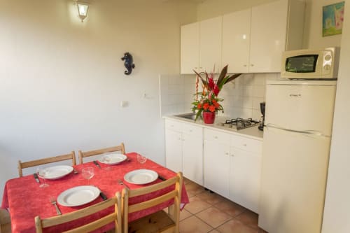 L'espace cuisine et repas en extérieur, sous terrasse, avec jolie vue mer/jardin/piscine, pour un séjour reposant aux jardins de l'espérance à Bouillante en Guadeloupe