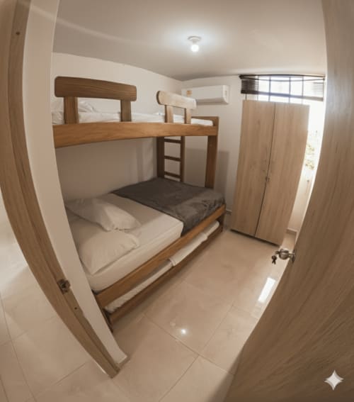 Literas con estructura de madera y ropa de cama blanca en una luminosa habitación del hotel Olamar Living en Santiago de Tolú, Colombia