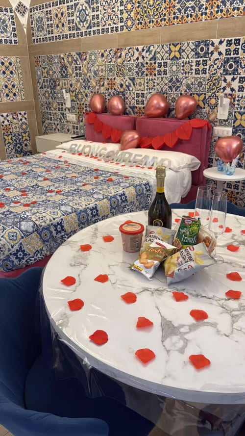 Romantica camera da letto per San Valentino presso San Nicola Suite Mini Apartments a Sorrento con palloncini a forma di cuore e petali di rosa