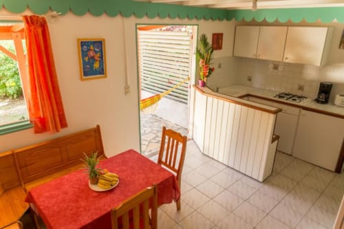 La cuisine ouverte sur le séjour de la location Alpinia aux jardins de Pointe Noire, avec son jardin tropical privatif. Vacances en famille réussies