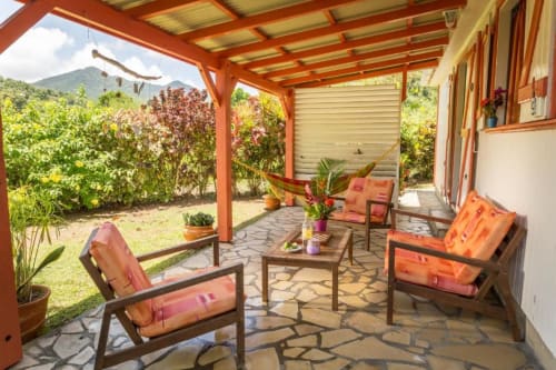 Terrasse colorée du gîte Alpinia, avec son jardin privatif, et sa végétation tropicale luxuriante, aux jardins de Pointe Noire en Guadeloupe
