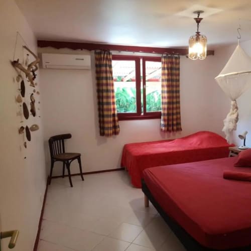 La jolie chambre rouge climatisée pour 3 personnes, dans la villa Hibiscus. C'est aux jardins de pointe noire en Guadeloupe