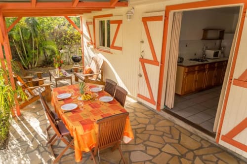 la jolie terrasse colorée de l'hébergement Ixora, entouré d'une végétation luxuriante, pour un séjour proche de la nature
