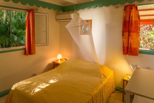Chambre climatisée, avec moustiquaire du logement Alpinia, pour des nuits reposantes, aux Jardins de Pointe Noire en Guadeloupe