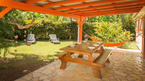 La belle terrasse arrière de la Villa Hibiscus pour 6 à 9 personnes avec son deuxième espace repas, hamac, barbecue et transats, pour des vacances tranquilles aux Jardins de Pointe Noire en Guadeloupe
