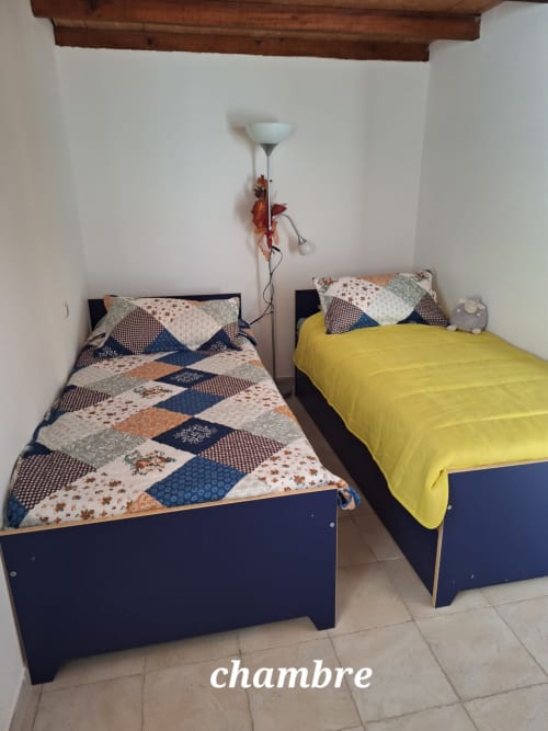 Two single beds with patchwork quilts in Mana Bleu apartment, managed by Corsu  di Core