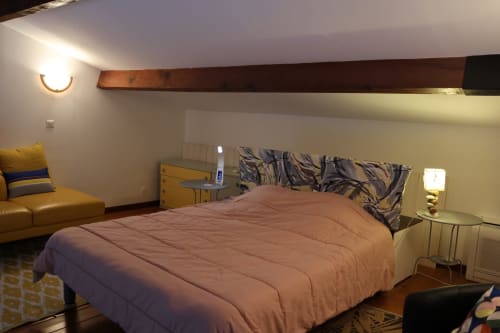 Cozy bedroom in Mana Bleu apartment, Favone with queen bed, yellow sofa, and sea view lighting, managed by Corsu di Core