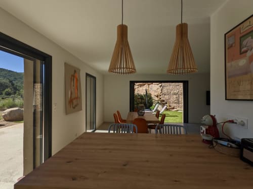 Modern villa dining area with wooden floor, pendant lights, and open views to courtyard pool at O Bord de Mer villa, managed by Corsu di Core