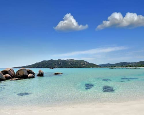 Turquoise beach with granite rocks and forested island, Porto-Vecchio