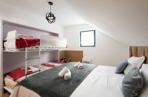 Charmantes Zimmer mit Kingsize-Bett, ideal für bis zu 4 Personen. Ein ausziehbares Etagenbett bietet zusätzlichen Schlafplatz und maximiert die Kapazität. Die moderne und helle Einrichtung sorgt für eine warme und behagliche Atmosphäre.
