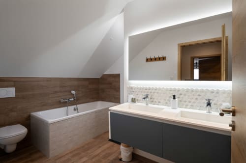 Ein modernes und elegantes Badezimmer mit Doppelwaschbecken und großem, beleuchtetem Spiegel. Für optimalen Komfort sorgen eine ebenerdige Dusche und eine Badewanne. Das wandhängende WC unterstreicht das klare Design.

Die Atmosphäre ist warm und der Raum gleichermaßen praktisch wie ästhetisch ansprechend – für Ihr Wohlbefinden.
