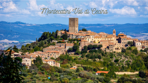 Montecatini Val di Cecina, villaggio medievale in collina con torre antica, edifici in terracotta e paesaggio toscano ondulato
