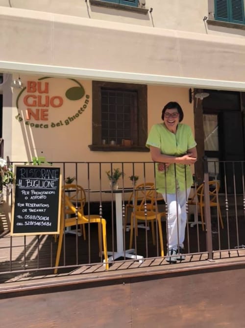 Donna in camicia verde all'ingresso del ristorante Il Buglione a Montecatini Val di Cecina