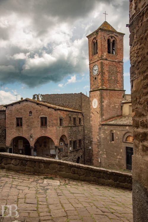 Torre medievale in mattoni con orologio nella corte di Montecatini Val di Cecina presso I Castagnini B&B