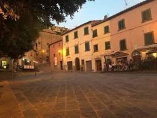 La corte di I Castagnini BnB al tramonto a Montecatini Val di Cecina con edifici in terracotta e piazza pavimentata