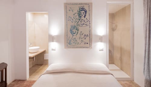 Modern bedroom at Case Zucco B&B in Terrasini with ensuite bathroom, white bedding, and decorative blue artwork