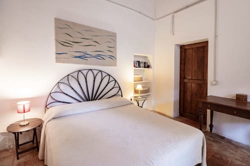 Bright bedroom at Case Zucco guesthouse in Terrasini with artistic metal headboard and modern decor