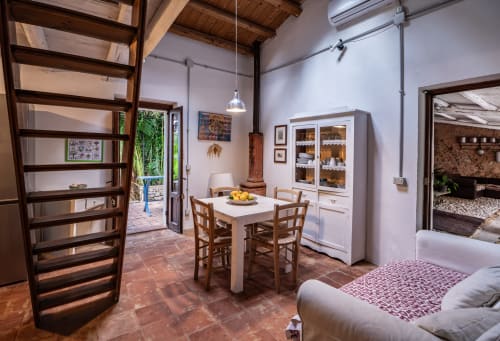 Case Zucco B&B bedroom in Terrasini with dining table, wooden furnishings, and terracotta flooring
