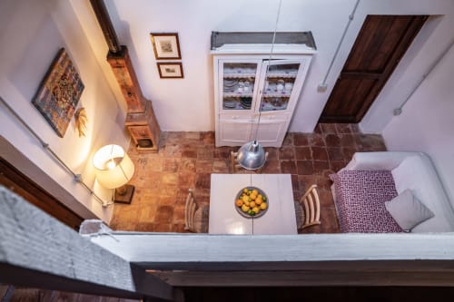 Overhead view of Case Zucco bedroom in Terrasini with terracotta floors, bed, dining table with fruit bowl, and white