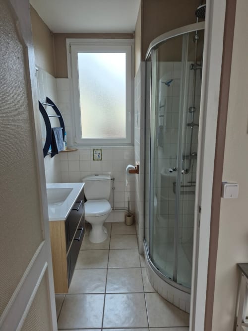 Salle de bain moderne avec douche, lavabo et toilettes au gîte Le Moulin Garnier à Vernou sur Brenne, France