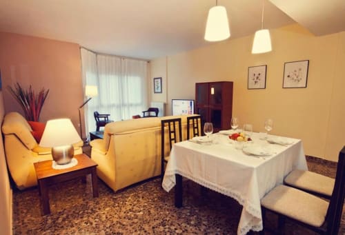 Suite espaciosa en Mérida con comedor, asientos amarillos y vistas a la ciudad en el hotel Gestyp-AT