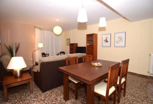 Apartamento moderno en Mérida con mesa de comedor, área de estar, muebles de madera e iluminación cálida