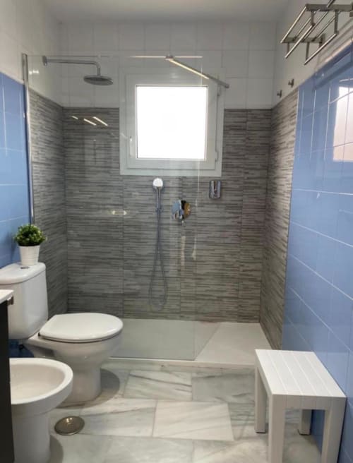 Cuarto de baño moderno en cabaña Gestyp-AT, Mérida con ducha a ras de suelo, doble lavamanos y detalles en azulejos azules