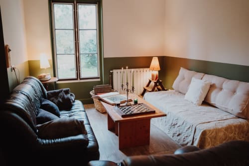 Baccara Lodge bedroom in Arengosse with bed, leather seating, radiator, and large windows overlooking garden